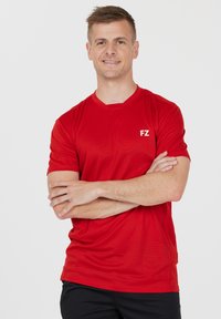 Rød sports T-shirt lavet af letvægtsstof med rund hals, der har et hvidt "FZ" logo på venstre brystområde. Blød tekstur.