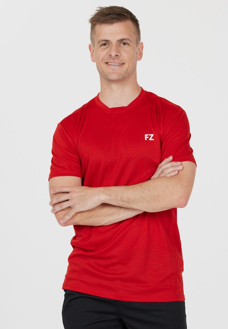 Rød sports T-shirt lavet af letvægtsstof med rund hals, der har et hvidt "FZ" logo på venstre brystområde. Blød tekstur.