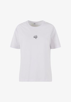 Valge puuvillane T-särk lühikeste varrukatega, mille rinnal on must tikandiga lotuse õie muster. Klassikaline ümar kaelus, vabalt langev lõige.