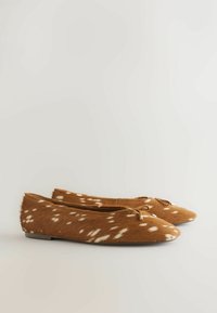 Chaussures de ballet plates marron avec motif à pois blancs et petit détail nœud sur fond clair uni