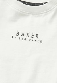 Weißes Baumwoll-T-Shirt mit schwarzem "BAKER BY TED BAKER" Text in Blockschrift über der Brust. Glatte Textur, runder Ausschnitt.