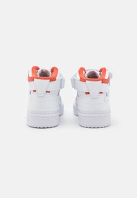 White high-top sneakers with orange accents and velcro straps. Smooth leather upper, padded collar, and textured rubber sole.