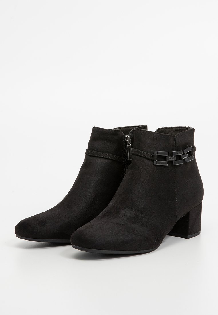 Bottes noires en daim à talons blocs avec un détail de chaîne décoratif sur le côté extérieur. Fermeture éclair sur le côté pour un enfilage facile.