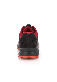 Des chaussures de sport noires et rouges avec une tige en mesh, des accents contrastants et une semelle en caoutchouc texturée, vues de l'arrière.