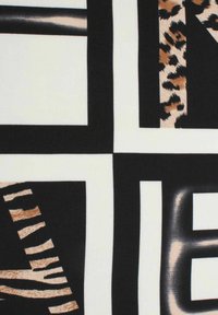 Patterned fabric featuring bold, black and white geometric shapes with leopard and zebra prints in shades of brown and cream.