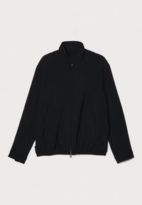 Fekete cipzáras dzseki, magas gallérral, elasztikus derékpánttal, texturált anyagból készült, és két oldalsó zsebbel rendelkezik. Sima felület, laza szabással.