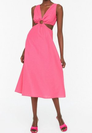 Roze mouwloze jurk met een diepe V-hals en een cirkelvormige uitsparing ter hoogte van de taille. Uitlopende rok valt net onder de knie, gemaakt van een gladde stof.