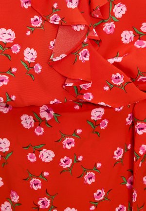 Rode stof met een bloemenpatroon; bevat roze bloemen en groene bladeren. Rimpeldetail langs de halslijn voegt textuur toe.