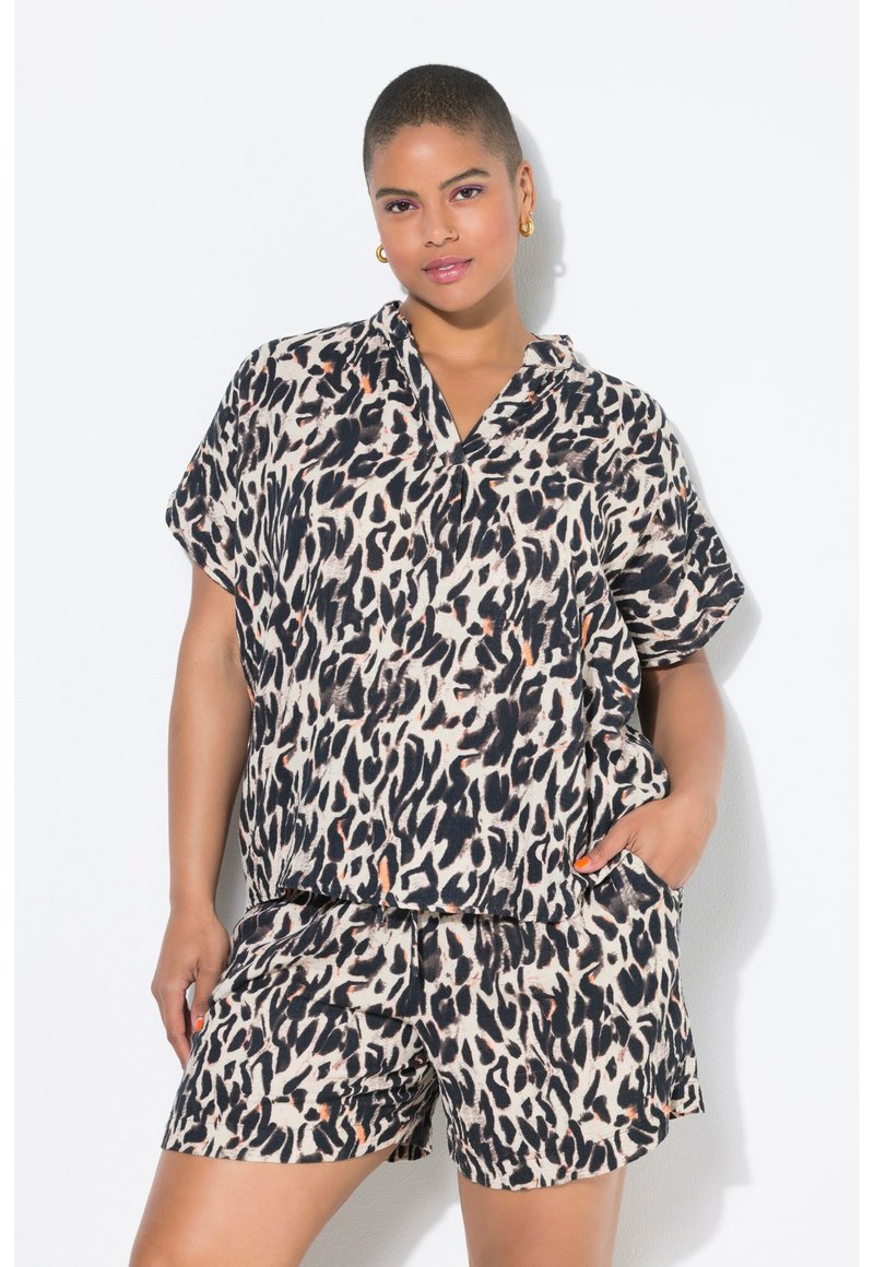 Camicia a maniche corte con stampa leopardata e pantaloni corti coordinati in beige chiaro con accenti neri e arancioni; vestibilità rilassata con tasche laterali.