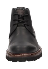 Bottine en cuir noir à bout rond, avec un laçage à l'avant et une semelle en caoutchouc. Présente des détails cousus et un accent de marque subtil.