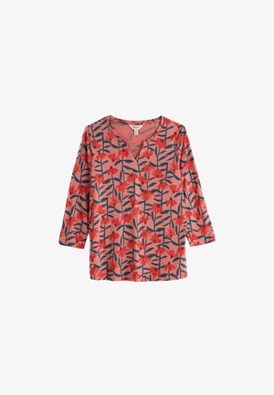 Roza bluza z dolgimi rokavi z rdečim cvetličnim vzorcem in temno zelenimi stebli, z V-izrezom in sproščenim krojem.