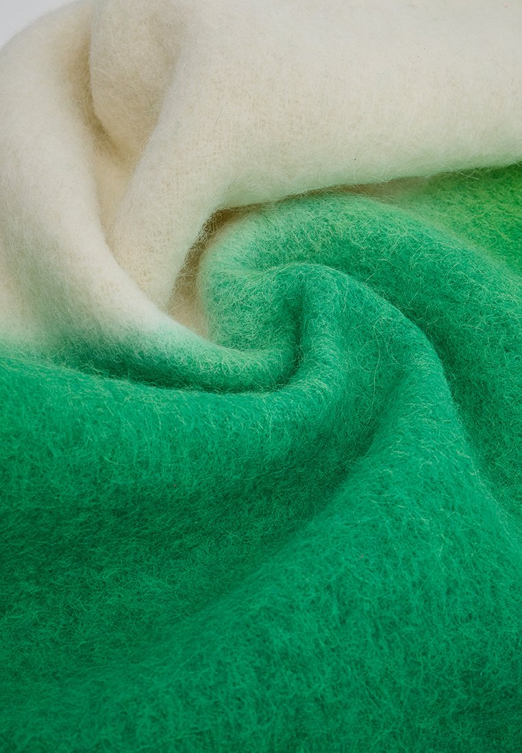 Wollfilz-Textil mit einem Farbverlauf von hellem Creme bis tiefem Grün, das eine weiche, strukturierte Oberfläche und einen nahtlosen Übergang zwischen den Farben aufweist.