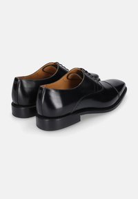 Schwarze Leder-Dressschuhe mit glatter Oberfläche, klassischem Schnürdesign, spitzer Zehenform und dezenten Seitenstitching-Details.