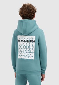 Lichtblauwe hoodie met een gestructureerde witte graphic op de achterkant met variërende typografie. De hoodie heeft een grote capuchon en geribbelde manchetten.