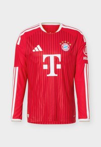 Punainen pitkähiha FC Bayern Münchenin jalkapallopaita, jossa valkoiset Adidas- ja Telekom-logot, seuramerkki viidellä tähdellä ja valkoiset olkaviirut.