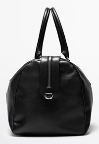 Schwarze Ledertasche mit doppelten Griffen, einem zentralen Reißverschlussdetail und einer kleinen Metallöse auf der Vorderseite vor einfarbigem Hintergrund.