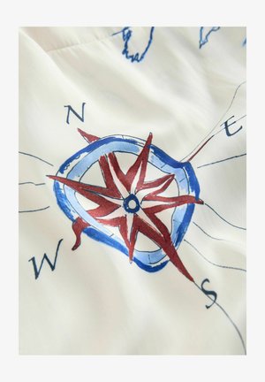 Rød og blå kompasrose med kardinalretningerne (N, S, Ø, V) på rynket hvidt stofbaggrund.