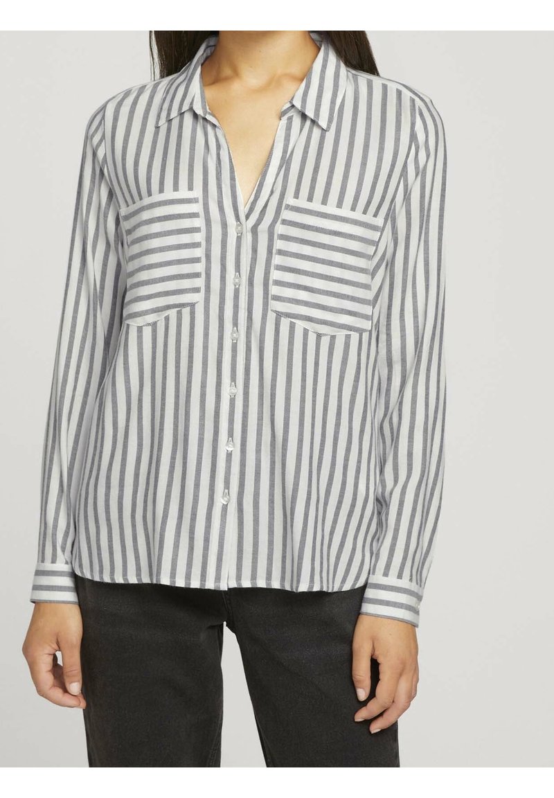 Camisa de botones a rayas en gris claro y gris oscuro, con cuello, dos bolsillos en el pecho y mangas largas con puños a rayas.