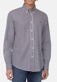 Camicia a maniche lunghe a righe in blu navy e bianco, con colletto button-down, bottoni frontali e un logo accento sul petto.