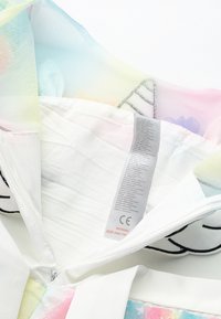 Colorful zippered garment with a pastel mesh lining, featuring floral patterns. Care label visible inside; materials include fabric and mesh.