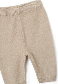 Pantalons pour bébé en tricot beige avec une taille côtelée, présentant une texture douce, des ouvertures de jambes fuselées et des coutures détaillées le long des seams.