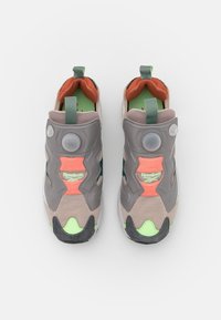 Baskets de sport grises et corail en matériaux synthétiques et en maille, avec textures, accents distinctifs et un bouton de pompe circulaire.