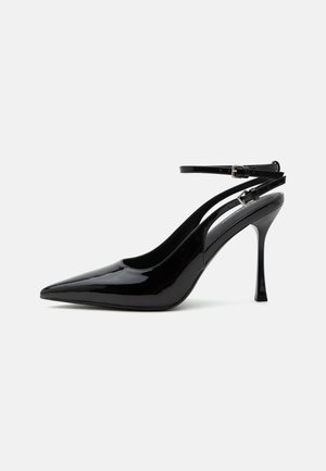 Black patent leather high-heeled slingback shoe with pointed toe and double ankle straps with silver buckles.