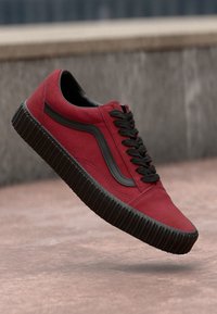 Sneaker rossa in suede con accenti neri e suola in gomma. Design con lacci e dettaglio a striscia laterale, dotata di suola texturizzata per una migliore aderenza.