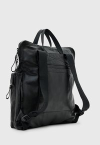 Černý kožený batoh s nastavitelnými látkovými popruhy, zipovým hlavním oddílem a bočními kapsami. Hladký povrch s minimalistickým designem.