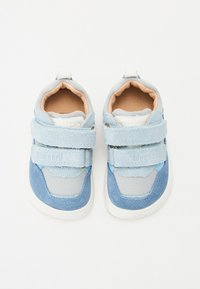 Zapatillas de deporte azul y gris con una combinación de materiales de gamuza y malla, que cuentan con correas de Velcro, cuellos acolchados y una suela blanca de goma.