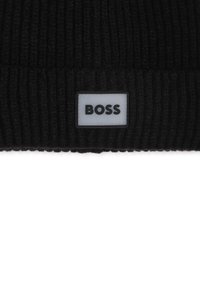 Czarna dzianinowa czapka o prążkowanej strukturze, z prostokątną szaro-skalową naszywką z logo, na której słowo "BOSS" jest wytłoczone na czarno.