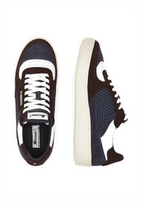 Zapatillas con malla azul marino, acentos de ante marrón oscuro, paneles de cuero blanco y una suela de goma crema. Diseño clásico con cordones.