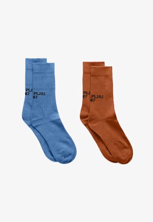 Two pairs of crew socks, one blue and one rust orange, each with black "PJ RJ 87" text near the ankle.