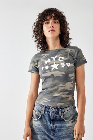 T-shirt gris camouflage avec le texte blanc "NYC 1990" et un motif d'étoile. Manches courtes, coupe ajustée, texture douce, associé à un jean bleu clair.