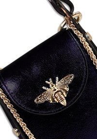 Zwarte laarzen van gepolijst leer met een gouden metalen bij als accent en een kettingstrap. Heeft een afgeronde klep sluiting en een glanzende textuur.