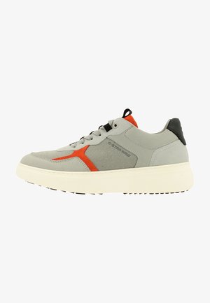Gray athletic shoe with an orange accent and black heel. Features textured upper and a thick white sole with a patterned bottom.