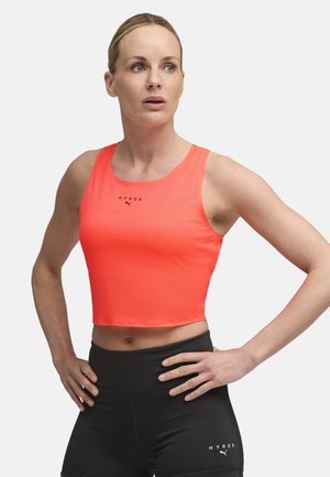 Bright neon orange athletic crop top with a textured fabric and a round neckline, paired with high-waisted black workout leggings.
