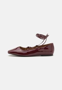 Burgundy patent leather ballet flat with a pointed toe, flat sole, and thin ankle strap. Smooth texture with minimal detailing.