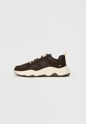 Brown suede sneaker with mesh accents, white sole, and cream laces. Features a padded collar and subtle logo on the heel.