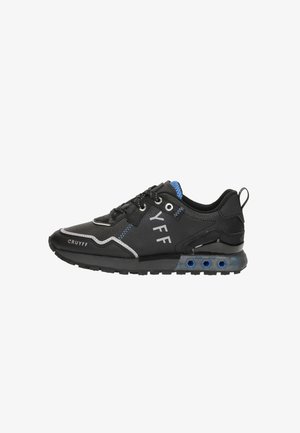 Black athletic shoe made of synthetic materials, featuring blue accents, textured surface, and a cushioned sole with ventilation holes.