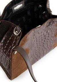 Bruine handtas met een combinatie van geprofileerd krokodillenleer en glad leer, met een ruime binnenkant en een ritsvak voor veilige opslag.