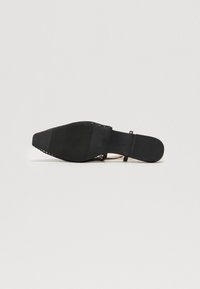 Sandal à talons noirs avec un bout pointu, une tige en mesh et une semelle noire unie. Dispose d'un dos fermé et d'une sangle à la cheville réglable.