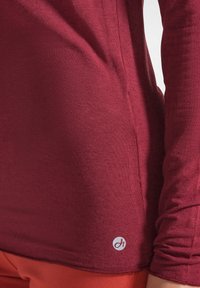 Langarmshirt in bordeauxrood, met een getailleerd ontwerp, een gladde textuur en een klein logodetail aan de onderzoom.