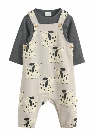 Beige babyromper met zwartgevlekt hondenprint, gedragen over een donkergrijze, geribbelde longsleeve met houten knoopdetails.