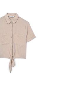 Camicia beige a maniche corte realizzata in tessuto texture, con chiusura a bottoni frontale, due tasche sul petto e dettaglio del fondo annodato.