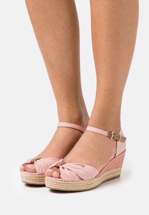 Roze wiggen sandalen met een geknoopte stoffen bovenzijde en enkelbandje, voorzien van een geweven jute buitenzool en subtiele contrasterende accenten.