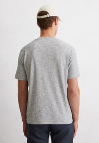 Grijze, korte mouwen t-shirt met een subtiel gestreept patroon, gemaakt van zachte stof. De achterkant toont een ronde hals en een relaxte pasvorm.
