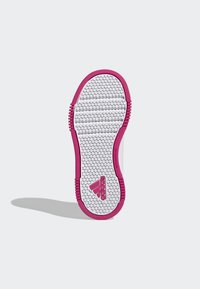 Semelle de sneaker blanche avec un motif hexagonal et des accents en caoutchouc rose, présentant un design anti-marque et une surface texturée pour une meilleure adhérence.