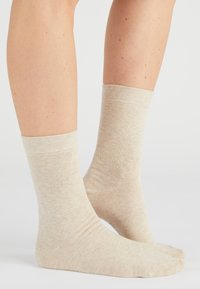 Beige katoenen sokken met een zachte textuur, middenkuitlengte en geribbelde boorden. Naadloos teenontwerp voor comfort en een gladde afwerking.
