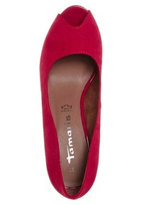 Chaussure plate à bout ouvert en daim rouge avec une semelle intérieure en cuir marron portant la marque "Tamaris" et la taille 37 visible.